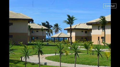 a row of houses with palm trees in a park at VG Sun Cumbuco in Cumbuco