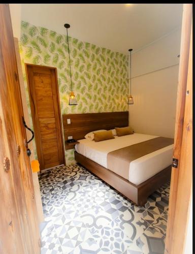 a bedroom with a bed in a room with a door at Casa Hotel Bremen in Circasia