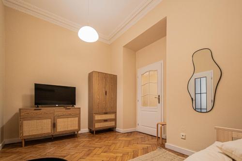 a living room with a flat screen tv and a mirror at Radost Residence The Heart of Unique Living in Prague