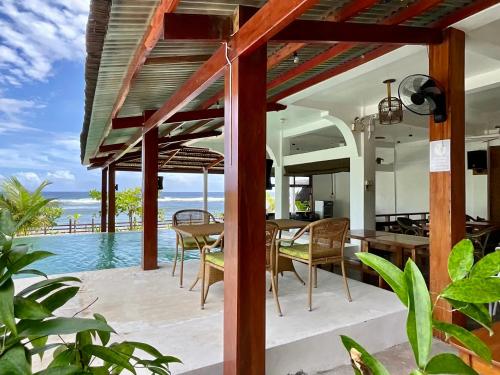 an outdoor patio with a table and chairs and a pool at Yapak Beach Villas in San Isidro