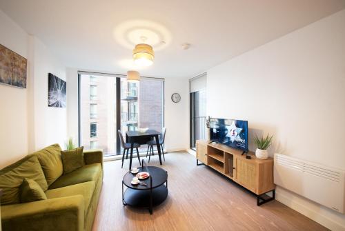 a living room with a couch and a table at Modern 1-Bed Apartment Near City Centre, Arndale, Spinningfields, MediaCityUK, Old Trafford & Etihad, Sleeps 4, Netflix, Gym, Balcony, Nespresso Machine, Perfect for Long & Short Stays, Leisure, Contractors & Professionals! in Manchester