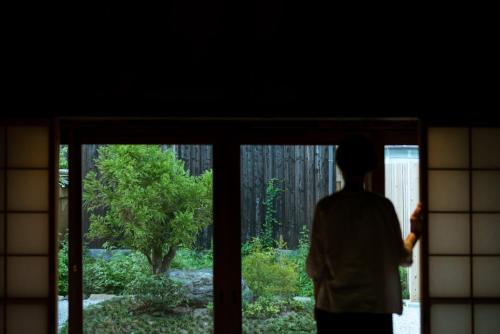 a person looking out of a window at a garden at Yasoichi in Tamba-sasayama