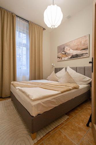 a bedroom with a large bed with a chandelier at Radost Residence The Heart of Unique Living in Prague