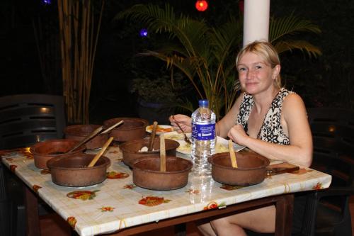 a woman sitting at a table with pots of food at Nature World Udawalawe in Udawalawe