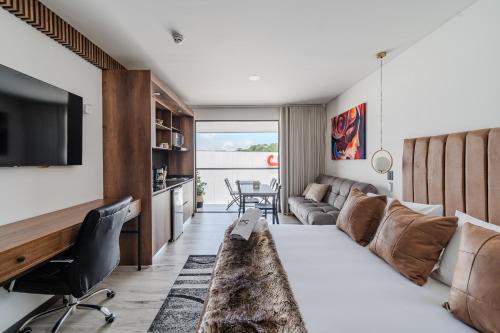 a room with a bed and a couch and a tv at Epic Suites x Ahead in Pereira