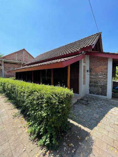 a brick building with a hedge in front of it at Saka Homestay Boutique & Cafe in Borobudur