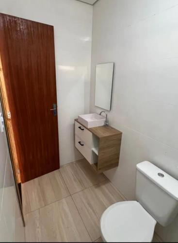 a bathroom with a toilet and a sink and a mirror at Casa Rebello - Pousada in Itajaí