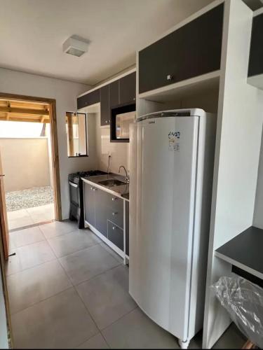 a kitchen with a stainless steel refrigerator in it at Casa Rebello - Pousada in Itajaí
