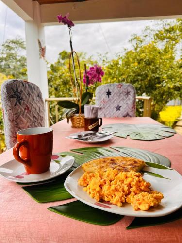a table with a plate of food and a cup of coffee at Cabaña Campestre Santa Helena in Choachí