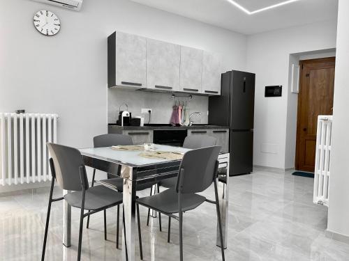a kitchen with a table and chairs and a black refrigerator at Il Belvedere dei Bizantini Apartaments in Melfi