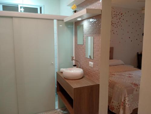 a bathroom with a sink and a bed at LOFT NOVO CONFORTÁVEL in Sorocaba