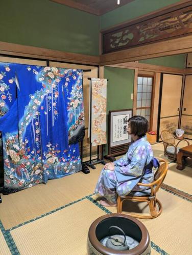 a woman sitting in a chair in a room at ようこそ月の宿へ in Shindembaru