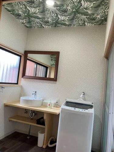 a bathroom with a sink and a mirror at ようこそ月の宿へ in Shindembaru