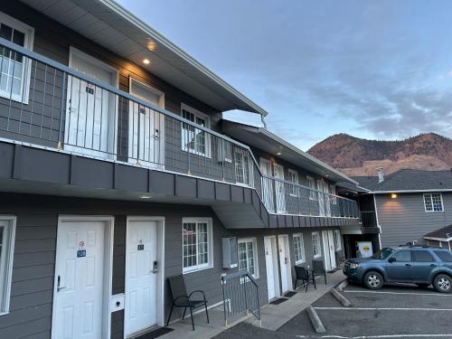 a building with a car parked in a parking lot at Kings Motor Inn in Kamloops