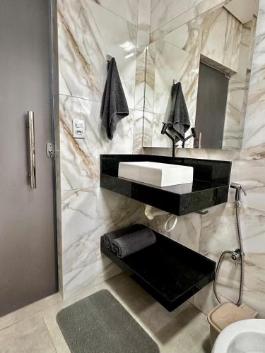 a bathroom with a sink and a mirror at Apartamento Palmeira Espaço Conforto e Conectividade em Formosa in Formosa