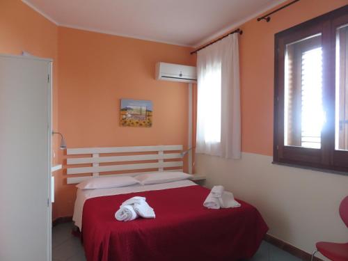 a bedroom with a red bed with towels on it at Case Vacanze Residence Trinacria in Acireale