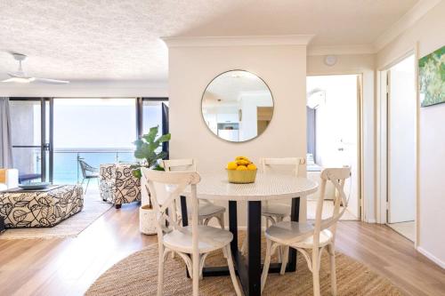 a dining room with a table and chairs and a mirror at Ocean Front Escape on Palm Beach in Gold Coast