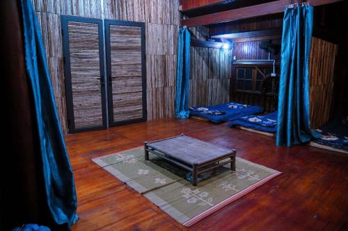 a room with a table on a wooden floor at Time Travel - Ha Giang Loop Tour in Ha Giang