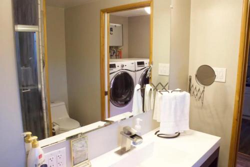 a bathroom with a sink and a washing machine at Private Home - Playground, Jumping Mat, BBQ, Darts, Firepit, Gazebo, 4 Smart TVs, White Cotton Bedding, - The Redwood Cul-De Sac Beach Retreat in Crescent City