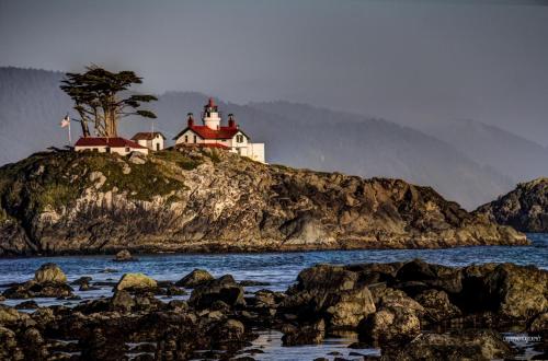 a house on top of a rocky island in the water at Private Home - Playground, Jumping Mat, BBQ, Darts, Firepit, Gazebo, 4 Smart TVs, White Cotton Bedding, - The Redwood Cul-De Sac Beach Retreat in Crescent City