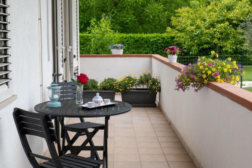 een kleine tafel en stoelen op een balkon met bloemen bij Parco delle Rose in Sulmona