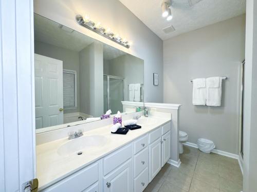 a bathroom with a sink and a large mirror at Cozy 3BR Home Near ATL Airport in Fairburn