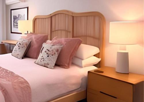 a bedroom with a bed with pink and white pillows at Between the City and the Sea w/ King Size Bed in Perth