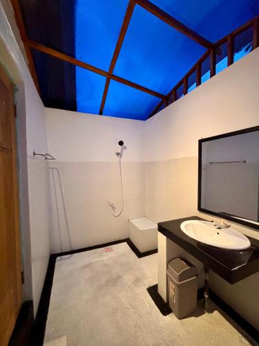 a bathroom with a sink and a blue ceiling at MAI LAKU Cottage in Sekotong