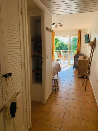 a hallway with a door open to a room with a table at TI KAZ DOUDOU - village de vacances bord de mer in Sainte-Anne