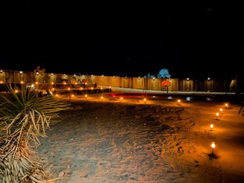 einen Zaun mit Lichtern am Strand in der Nacht in der Unterkunft Private Home - Heated Saltwater Pool, BBQ, Pro Pool Table, Horseshoes, Darts, Cotton Bedding, Half Acre - The Joshua Tree Forest - Pool Heat Optional in Twentynine Palms