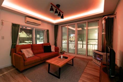a living room with a red couch and a table at THE SUNLIGHT in Sapporo