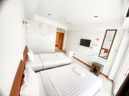 a small room with two beds and a mirror at โรงแรม บ้านริมโขง in Ban Nong Puk
