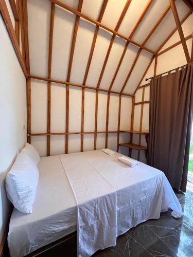a bedroom with a bed in a room at MAI LAKU Cottage in Sekotong