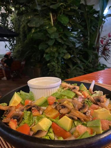 a salad in a black bowl on a table at La Vaina Cali in Cali