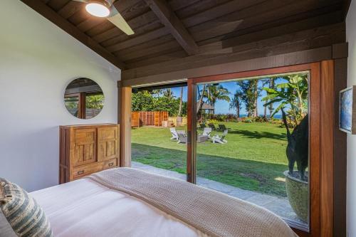 a bedroom with a large glass door leading to a yard at Hale Maluhia Hanalei home in Hanalei