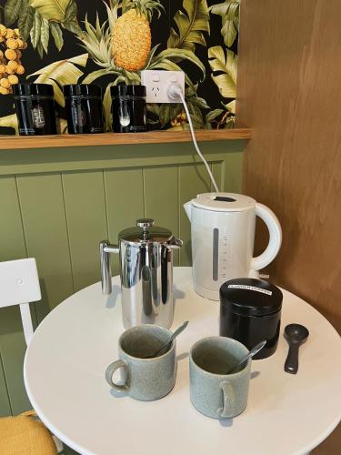 a table with two cups and a coffee maker on it at Pyke Cottage, Clyde in Clyde