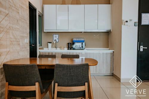 a kitchen with a wooden table and chairs in a room at Ipoh Majestic Premium Suites by Verve in Ipoh