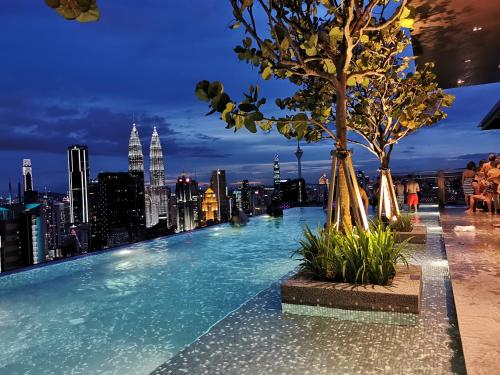 a infinity pool on the roof of a building with a city skyline at EXPRESSIONZ DESIGNER SUITES Host By AURORA PREMIUM STAY in Kuala Lumpur