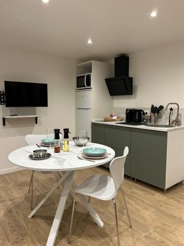 a kitchen with a table and chairs in a kitchen at Studio chic et cocon proche de Disney in Lagny
