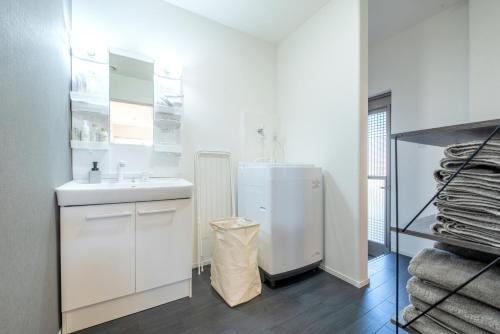 a white bathroom with a sink and a refrigerator at Villa RIKUNOYA SUZUKA in Suzuka