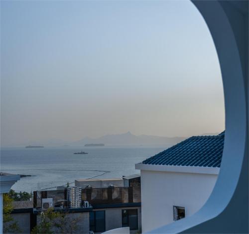 a view of the ocean from a building at Miyue Shenzhen Blue and White Holy Island Cliff Pool Hotel in Shenzhen
