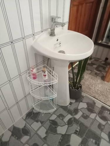 a bathroom with a sink and a basket next to it at Cozy breezing countryside Pet in Ban Khlong Sip Sam Lang