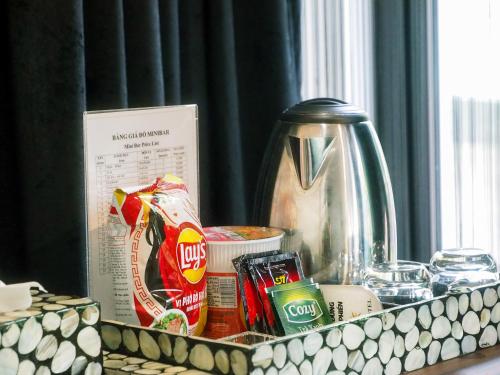 a counter top with food and drinks and a kettle at Rosa Hanoi Hotel in Hanoi