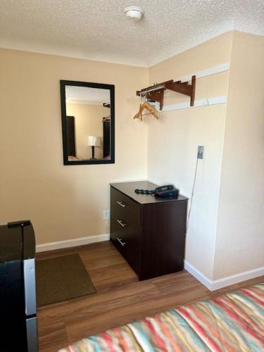 a room with a dresser and a mirror on the wall at Gratiot View Motel in Saginaw