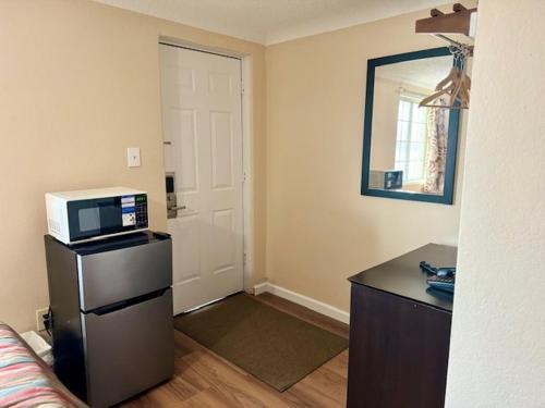 a room with a kitchen with a microwave and a door at Gratiot View Motel in Saginaw