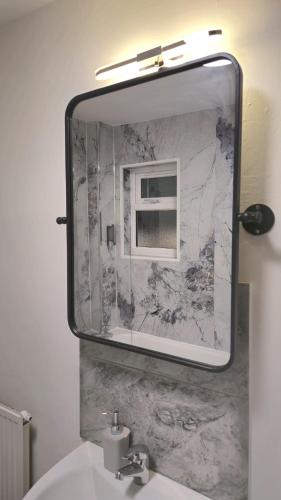 a mirror above a sink in a bathroom at Tyger Inn Derby in Derby