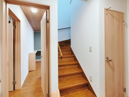 a staircase in a house with wooden flooring and blue ceilings at Lucky House Niseko in Kutchan