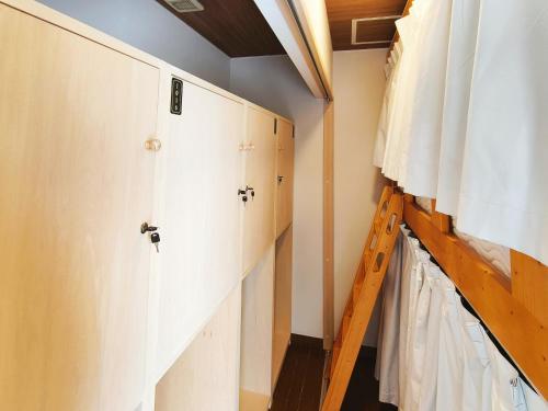a room with white cabinets and a ladder at Lucky House Niseko in Kutchan