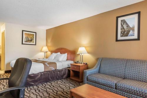 a hotel room with a bed and a couch at Quality Inn Charleston - Sikeston in Charleston