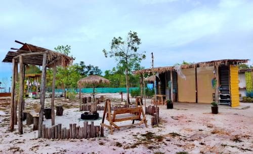 un bâtiment avec une clôture en bois et un bâtiment dans l'établissement Mai Rut Beach Eco Camping, à Ban Nong Wiwat